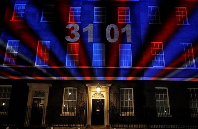 A countdown to Brexit timer and the colors of the British Union flag illuminate the exterior of 10 Downing street, the residence of the British Prime Minister, in London, England, Friday, Jan. 31, 2020. Britain officially leaves the European Union on Friday after a debilitating political period that has bitterly divided the nation since the 2016 Brexit referendum. (AP Photo/Kirsty Wigglesworth)