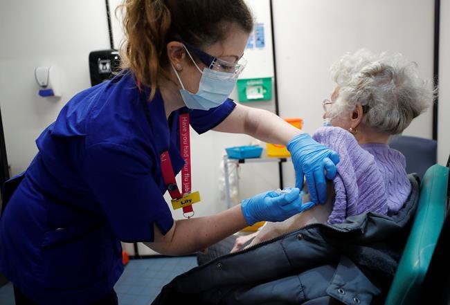 A nurse administers the Pfizer-BioNTech COVID-19 vaccine at Guy's Hospital in London, Tuesday, Dec. 8, 2020. U.K. health authorities rolled out the first doses of a widely tested and independently reviewed COVID-19 vaccine Tuesday, starting a global immunization program that is expected to gain momentum as more serums win approval. (AP Photo/Frank Augstein, Pool)