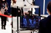 In this Jan. 16, 2020, photo, travelers from China's Wuhan go through body temperature scanners at Narita airport in Narita, near Tokyo. A fourth person has died in an outbreak of a new coronavirus in China, authorities said Tuesday, Jan. 21, 2020, as more places stepped up medical screening of travelers from the country as it enters its busiest travel period. (Kyodo News via AP)