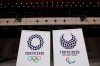 FILE - In this Feb. 2, 2020, file photo, two logo for the Tokyo 2020 Olympics and Paralympics, are displayed at a grand opening ceremony of the Ariake Arena, a venue for volleyball at the Tokyo 2020 Olympics and wheelchair basketball during the Paralympic Games, in Tokyo. A test event for the Tokyo Olympics scheduled for later February, that would have involved some non-Japanese athletes is being rejiggered because of fear of the spreading virus from China. It will now involve only Japanese athletes.(AP Photo/Jae C. Hong)