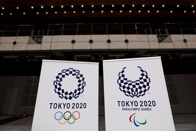FILE - In this Feb. 2, 2020, file photo, two logo for the Tokyo 2020 Olympics and Paralympics, are displayed at a grand opening ceremony of the Ariake Arena, a venue for volleyball at the Tokyo 2020 Olympics and wheelchair basketball during the Paralympic Games, in Tokyo. A test event for the Tokyo Olympics scheduled for later February, that would have involved some non-Japanese athletes is being rejiggered because of fear of the spreading virus from China. It will now involve only Japanese athletes.(AP Photo/Jae C. Hong)