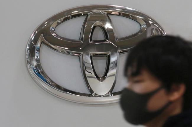 FILE - In this Nov. 2, 2020, file photo, visitor wearing a face mask to help curb the spread of the coronavirus walks by the logo of Toyota Motor Corp. at its showroom in Tokyo. Toyota won't be airing any Olympic-themed advertisements on Japanese TV during the Tokyo Games despite being one of the IOC's top corporate sponsors. The unusual decision by the country's top automaker underlines how polarizing the Games have become in Japan as COVID-19 infections rise ahead of the July 23, 2021, opening ceremony.(AP Photo/Koji Sasahara, File)