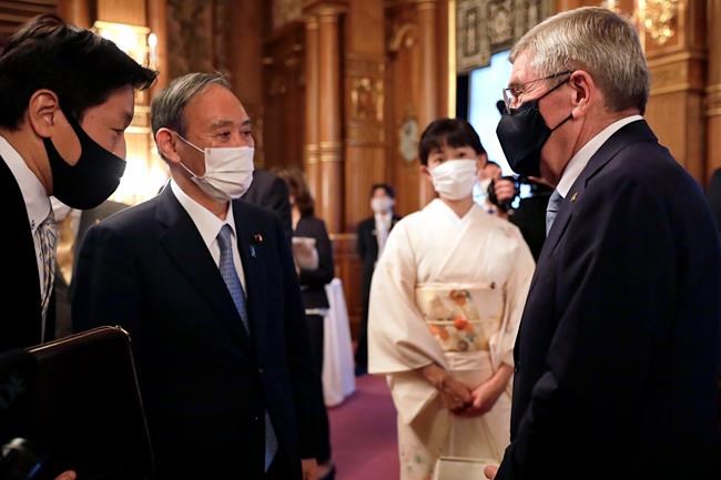 ADDS RESTRICTION: ONE TIME USE ONLY, EDITORIAL USE ONLY - IOC President Thomas Bach, right, meets with Japanese Prime Minister Yoshihide Suga, second from left, during a welcome party for Bach and IOC officials at Akasaka Palace, Japanese state guest house, in Tokyo, Japan, Sunday, July 18, 2021.(Courtesy of Tokyo 2020 via AP)