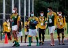 South Africa's Olympic soccer team members, wearing face masks, leave the training venue in Chiba, east of Tokyo, Monday, July 19, 2021. Two South African soccer players have become the first athletes inside the Olympic Village to test positive for COVID-19. The Tokyo Games open on Friday. (Kyodo News via AP)