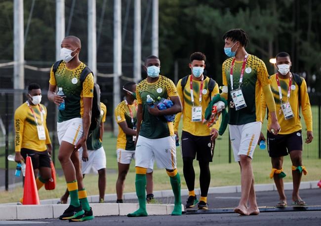 South Africa's Olympic soccer team members, wearing face masks, leave the training venue in Chiba, east of Tokyo, Monday, July 19, 2021. Two South African soccer players have become the first athletes inside the Olympic Village to test positive for COVID-19. The Tokyo Games open on Friday. (Kyodo News via AP)