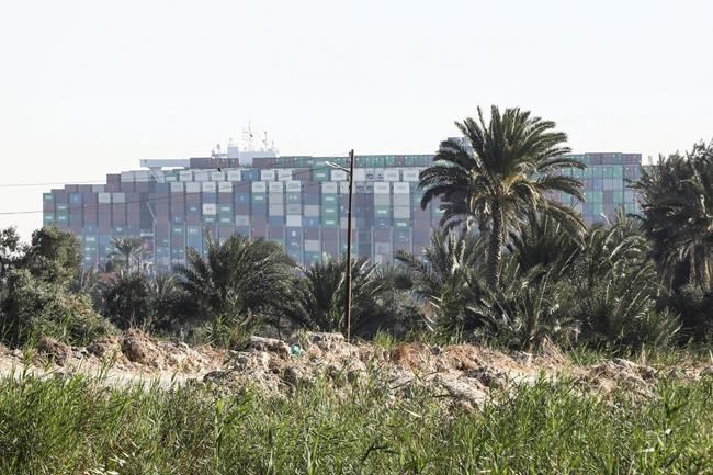 Ever Given, a Panama-flagged cargo ship that is wedged across the Suez Canal and blocking traffic in the vital waterway is seen Monday, March 29, 2021. Engineers on Monday “partially refloated” the colossal container ship that continues to block traffic through the Suez Canal, a canal services firm said, without providing further details about when the vessel would be fully set free. (AP Photo/Mohamed Elshahed)