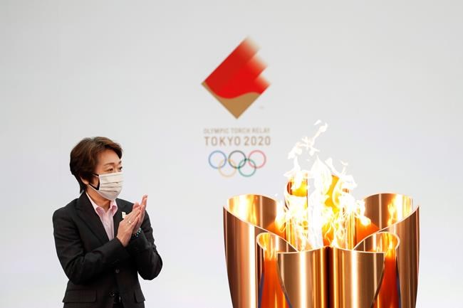 Tokyo 2020 Organizing Committee President Seiko Hashimoto applauds next to the celebration cauldron on the first day of the Tokyo 2020 Olympic torch relay in Naraha, Fukushima prefecture, northeastern Japan, Thursday, March 25, 2021. The torch relay for the postponed Tokyo Olympics began its 121-day journey across Japan on Thursday and is headed toward the opening ceremony in Tokyo on July 23. (Kim Kyung-Hoon/Pool Photo via AP)