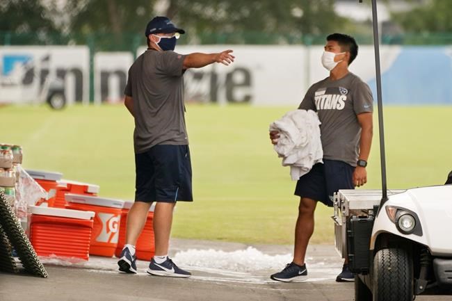 Tennessee Titans staff members remove items from the practice fields after practice was called off during NFL football training camp Thursday, Aug. 27, 2020, in Nashville, Tenn. (AP Photo/Mark Humphrey, Pool)