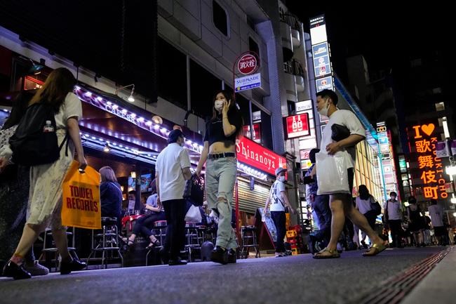 People walk around and gather at a bar after government imposed 8 p.m. closing time for restaurants and bars under Tokyo's fourth state of emergency Saturday, July 17, 2021, in Tokyo. The latest state of emergency has asked restaurants and bars to close by 8 p.m., if not entirely. This has pushed people to drink outside, although many bars remain open and bustling with customers who are defying the rules and expressing frustration and indifference. (AP Photo/Kiichiro Sato)