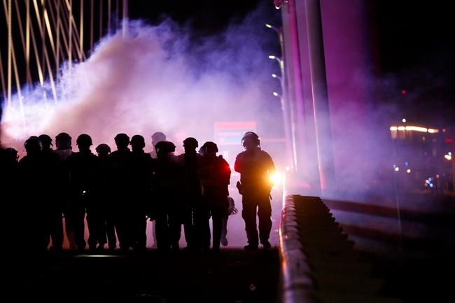 Police deploy smoke bombs and tear gas as they surround protesters who marched onto the Margaret Hunt Hill Bridge while demonstrating against police brutality on Monday, June 1, 2020, in Dallas. The hundreds of protesters were surrounded and detained by police on the bridge and transported to the Dallas County Jail where they were later released. (Ryan Michalesko/The Dallas Morning News via AP)