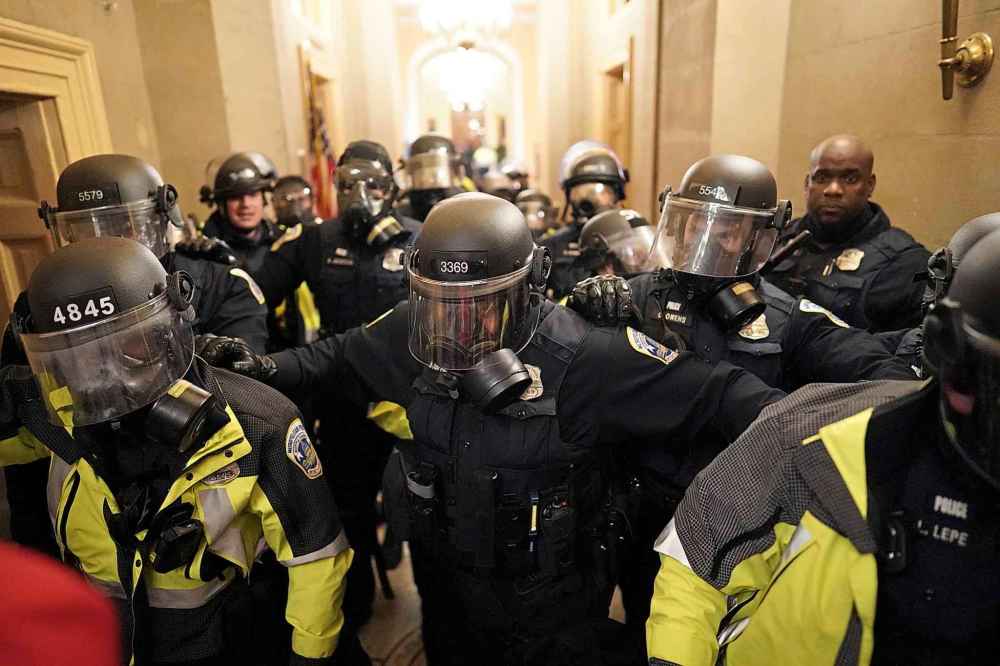 Riot police clear the hallway inside the Capitol on Wednesday, Jan. 6, 2021 in Washington, DC. (Kent Nishimura/Los Angeles Times/TNS)