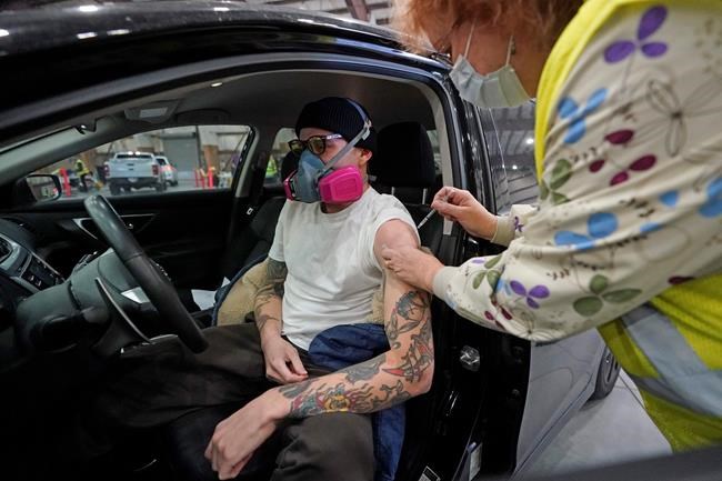James Lennox, IT technical support specialist for the Utah School for the Deaf and Blind gets the COVID-19 vaccine at the Davis County Legacy Center Tuesday, Jan. 12, 2021, in Farmington, Utah. Utah began vaccinating teachers and school staff across the state. They are aiming to have all teachers and school staff vaccinated by the end of February. (AP Photo/Rick Bowmer)