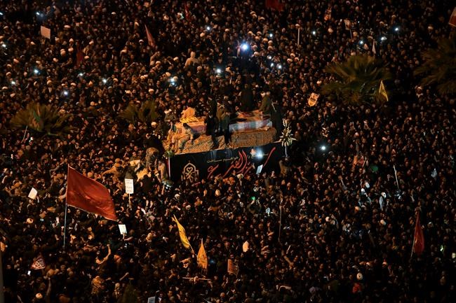 Mourners surround a truck carrying the flag draped coffins of Gen. Qassem Soleimani and his comrades in the holy city of Qom south of the capital Tehran, Iran, Monday, Jan. 6, 2020. The men were killed in a U.S. drone strike on Friday, Jan. 3 in Iraq. The funeral drew a crowd said by police to be in the millions in the Iranian capital, filling thoroughfares and side streets as far as the eye could see. (Amir Hesaminejad/Tasnim News Agency via AP)