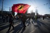 A man carries a Mohawk Warrior Society flag as protesters march on East Hastings St. in support of Wet'suwet'en Nation hereditary chiefs attempting to halt construction of a natural gas pipeline on their traditional territories, in Vancouver, B.C., Tuesday, Feb. 18, 2020. THE CANADIAN PRESS/Darryl Dyck