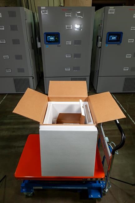 In this undated photo released by Pfizer on Tuesday, Dec. 1, 2020, a thermal shipping box for a COVID-19 candidate vaccine developed by BioNTech and Pfizer is shown in front of a freezers at the company headquarters in Puurs, Belgium. The potential vaccine is awaiting approval to use against the coronavirus. (Pfizer via AP)