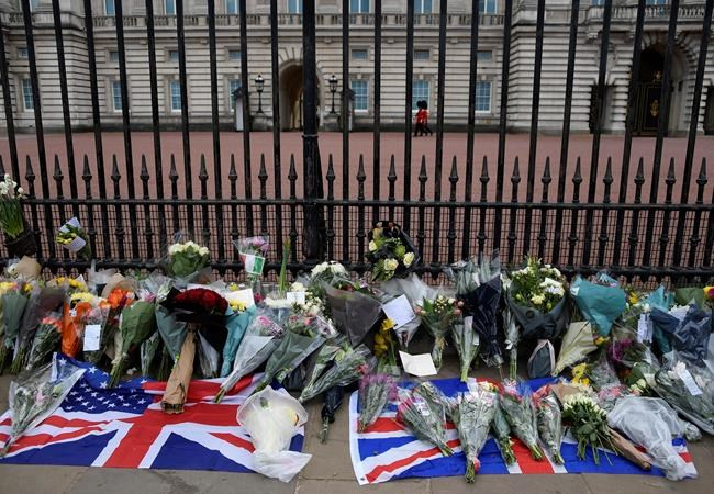 Flowers and other items are left by the public outside Buckingham Palace in London, Friday, April 9, 2021. Buckingham Palace officials say Prince Philip, the husband of Queen Elizabeth II, has died. He was 99. Philip spent a month in hospital earlier this year before being released on March 16 to return to Windsor Castle. (AP Photo/Alberto Pezzali)