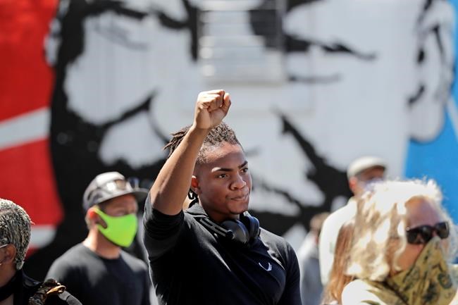 Hanz Jouissance holds up a fist at the conclusion of a prayer vigil at the First AME church Monday, June 1, 2020, in Seattle, following protests over the weekend over the death of George Floyd, a black man who was in police custody in Minneapolis. (AP Photo/Elaine Thompson)