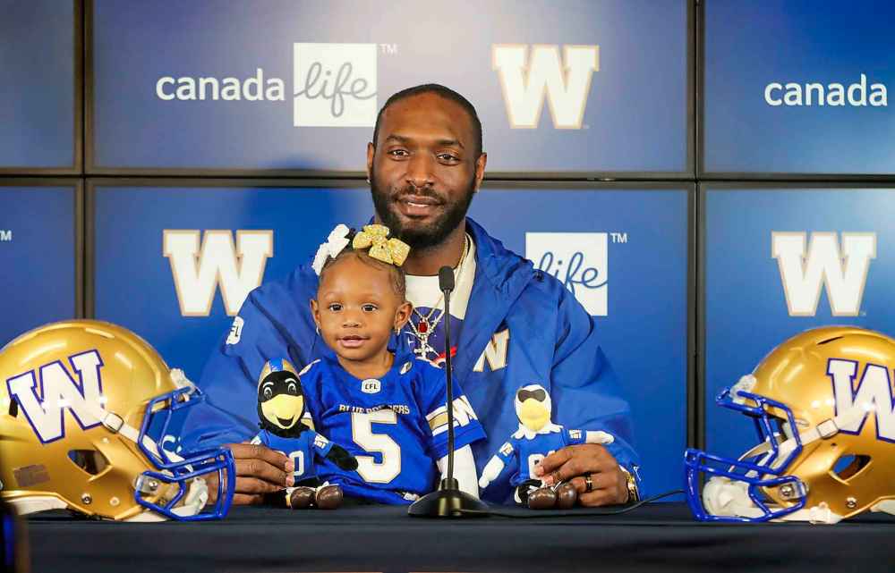 RUTH BONNEVILLE  /  WINNIPEG FREE PRESS 
Blue Bombers' Willie Jefferson, with his daughter 22-month-old Kelley, answers questions from the media about signing on with the Bombers for another 2 seasons on Thursday.
