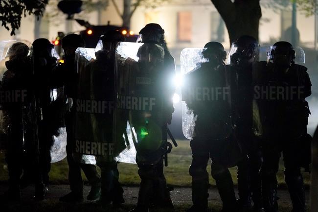 Law enforcement gather to address unrest Tuesday, Aug. 25, 2020 in Kenosha, Wis. Anger over the Sunday shooting of Jacob Blake, a Black man, by police spilled into the streets for a third night. (AP Photo/Morry Gash)