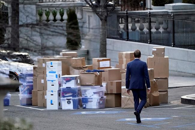 A man walks past boxes that were moved out of the Eisenhower Executive Office building, just outside the West Wing, inside the White House complex, Thursday, Jan. 14, 2021, in Washington. (AP Photo/Gerald Herbert)