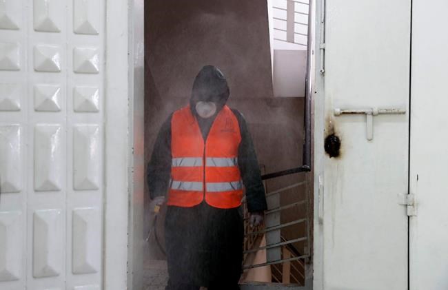 A worker wearing protective gear disinfects offices in the Gaza municipality to help prevent the spread of the new coronavirus, in Gaza City, Tuesday, March 10, 2020. For most people, the new coronavirus causes only mild or moderate symptoms, such as fever and cough. For some, especially older adults and people with existing health problems, it can cause more severe illness, including pneumonia. (AP Photo/Adel Hana)