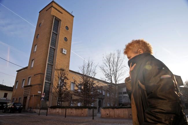 A woman covers her face as she walks in Codogno, near Lodi in Northern Italy, Friday, Feb. 21,2020. Health officials reported the country's first cases of contagion of COVID-19 in people who had not been in China. The hospital in Codogno is one of the hospitals - along with specialized Sacco Hospital in Milan - which is hosting the infected persons and the people that were in contact with them and are being isolated. (AP Photo/Luca Bruno)