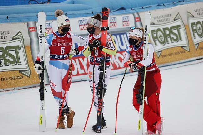 From left, second placed Switzerland's Corinne Suter, third placed Germany's Kira Weidle, and the winner, Switzerland's Lara Gut-Behrami talk in the finish area after an alpine ski, women's World Cup downhill, in Val di Fassa, Italy, Saturday, Feb. 27, 2021. (AP Photo/Alessandro Trovati)