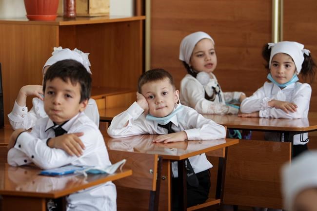 Pupils wearing face masks to protect against coronavirus sit in a classroom during a ceremony marking the start of classes at a school as part of the traditional opening of the school year known as