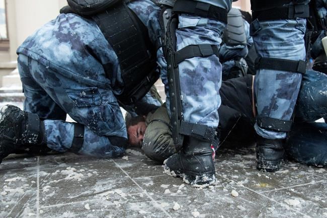 Police officers detain a man during a protest against the jailing of opposition leader Alexei Navalny in Moscow, Russia, on Sunday, Jan. 31, 2021. Tens of thousands of people are protesting across Russia to demand the release of jailed opposition leader Alexei Navalny in wave of nationwide demonstrations that have rattled the Kremlin. Many chanted slogans against President Vladimir Putin. Activists say police detained more than 3,300 protesters across the country on Sunday, including over 900 in Moscow. (AP Photo/Denis Kaminev)