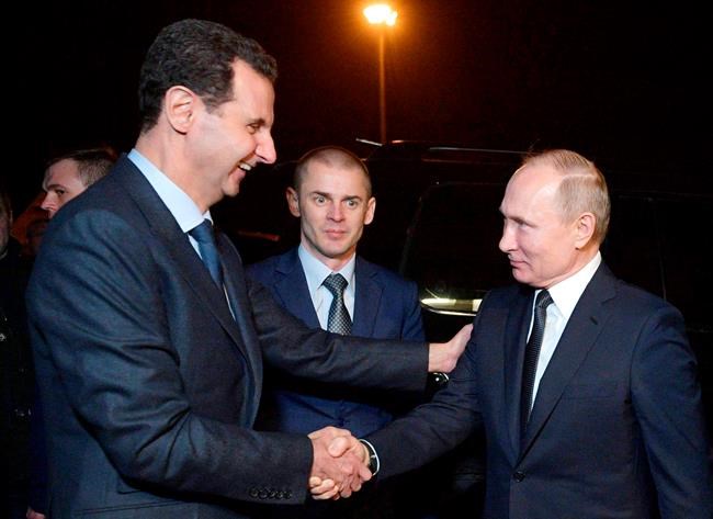 Russian President Vladimir Putin, right, and Syrian President Bashar Assad shake hands during their meeting in Damascus, Syria, Tuesday, Jan. 7, 2020. Putin has traveled to Syria to meet with President Bashar Assad, a key Iranian ally. The rare visit Tuesday comes amid soaring tensions between Iran and the United States following the U.S. drone strike last week that killed a top Iranian general who led forces supporting Assad in Syria's civil war. (Alexei Druzhinin, Sputnik, Kremlin Pool Photo via AP)