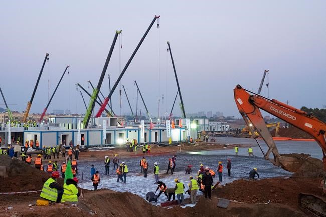 Construction workers labor at the site of the Huoshenshan temporary field hospital being built in Wuhan in central China's Hubei Province, Thursday, Jan. 30, 2020. China counted 170 deaths from a new virus Thursday and more countries reported infections, including some spread locally, as foreign evacuees from China's worst-hit region returned home to medical observation and even isolation. (AP Photo/Arek Rataj)