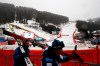 Skiers carry their skiis after an alpine ski, men's World Cup downhill was canceled due to bad weather, in Val Gardena, Italy, Saturday, Dec. 21, 2019. (AP Photo/Gabriele Facciotti)