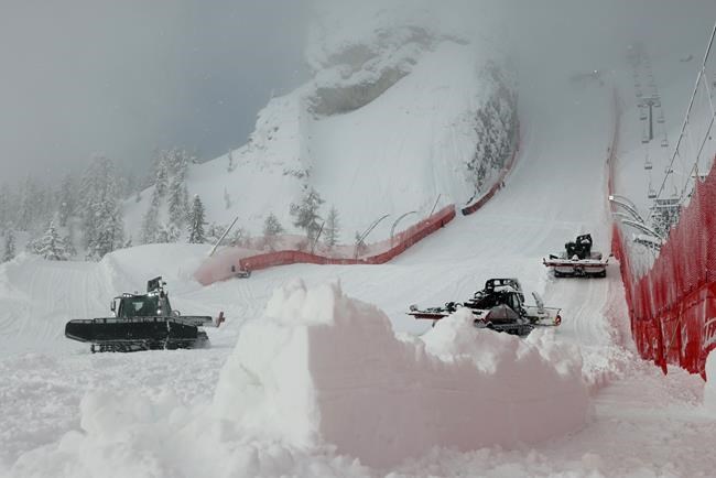 Snowcats clear the snow along the Olympia delle Tofane course after a women's alpine combined race was canceled due to heavy snowfall, at the alpine ski World Championships in Cortina d'Ampezzo, Italy, Monday, Feb. 8, 2021. (AP Photo/Marco Trovati)