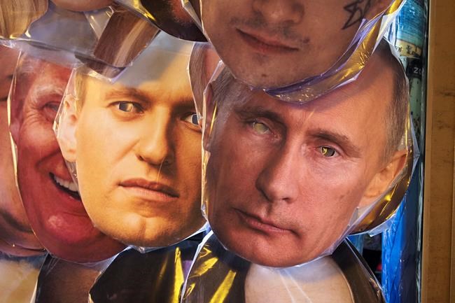 Face masks depicting Russian President Vladimir Putin, right, and Russian opposition leader Alexei Navalny, left of Putin, among others displayed for sale at a street souvenir shop in St.Petersburg, Russia, Sunday, Jan. 17, 2021. Top Kremlin critic Alexei Navalny says he will fly home to Russia on Sunday, Jan. 17, 2021, despite the Russian prison service's intention to put him behind bars for allegedly breaching the terms of his suspended sentence and probation. (AP Photo/Dmitri Lovetsky)
