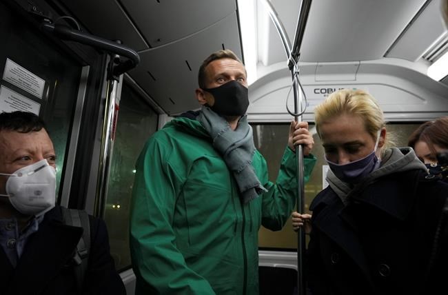 Alexei Navalny, centre, and his wife Yulia travel an airport bus as they arrived to airport Sheremetyevo, outside Moscow, Russia, Sunday, Jan. 17, 2021. Leading Kremlin critic Alexei Navalny arrived home to Russia on Sunday after recovering in Germany from his poisoning in August with a nerve agent. (AP Photo/Mstyslav Chernov)