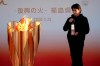 An official holds a lantern containing the Olympic Flame at the end of a flame display ceremony in Iwaki, northern Japan, Wednesday, March 25, 2020. IOC President Thomas Bach has agreed 