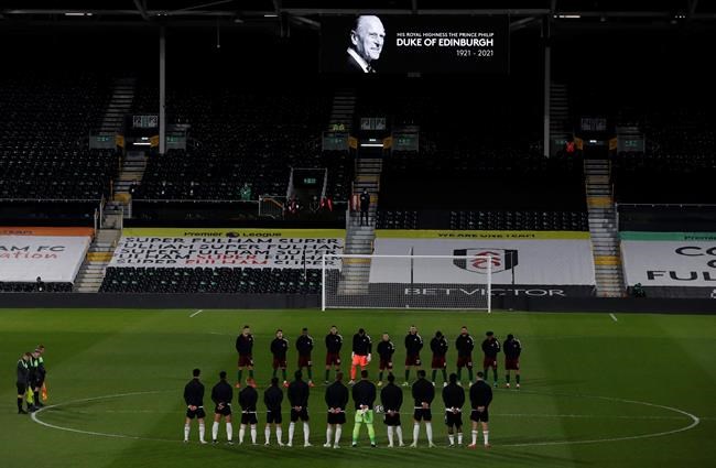 Players from both sides observe a minute's silence to honor Britain's Prince Philip, Duke of Edinburgh, after the announcement of the death today, before the English Premier League soccer match between Fulham and Wolverhampton Wanderers at Craven Cottage stadium in London, England, Friday, April 9, 2021.(Andrew Couldridge/Pool via AP)