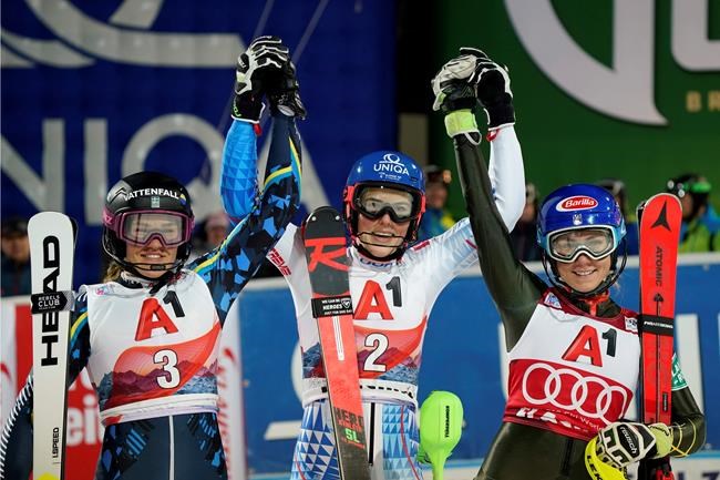 From left, second placed Sweden's Anna Swenn Larsson, the winner Slovakia's Petra Vlhova, and third placed United States' Mikaela Shiffrin celebrate after completing an alpine ski, women's World Cup slalom in Flachau, Austria, Tuesday, Jan. 14, 2020. (AP Photo/Giovanni Auletta)