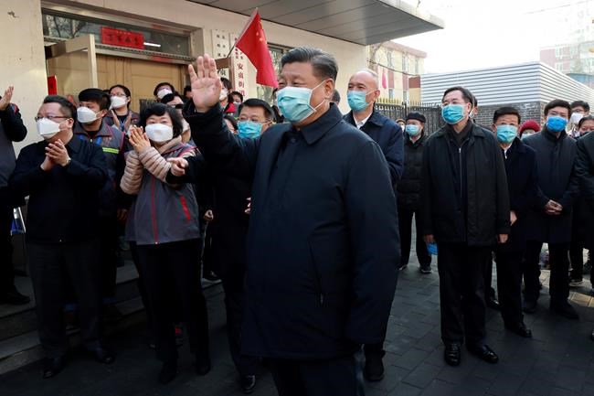 In this photo released by Xinhua News Agency, Chinese President Xi Jinping, centre, wearing a protective face mask waves as he inspects the novel coronavirus pneumonia prevention and control work at a neighbourhoods in Beijing, Monday, Feb. 10, 2020. China reported a rise in new virus cases on Monday, possibly denting optimism that its disease control measures like isolating major cities might be working, while Japan reported dozens of new cases aboard a quarantined cruise ship. (Pang Xinglei/Xinhua via AP)