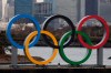 A worker is dwarfed by the Olympics Rings on a barge Friday, Jan. 17, 2020, in the Odaiba district of Tokyo. (AP Photo/Jae C. Hong)