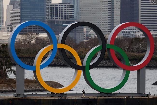 A worker is dwarfed by the Olympics Rings on a barge Friday, Jan. 17, 2020, in the Odaiba district of Tokyo. (AP Photo/Jae C. Hong)