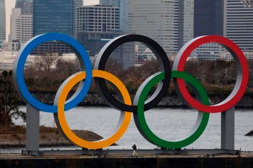 A worker is dwarfed by the Olympics Rings on a barge Friday, Jan. 17, 2020, in the Odaiba district of Tokyo. (AP Photo/Jae C. Hong)