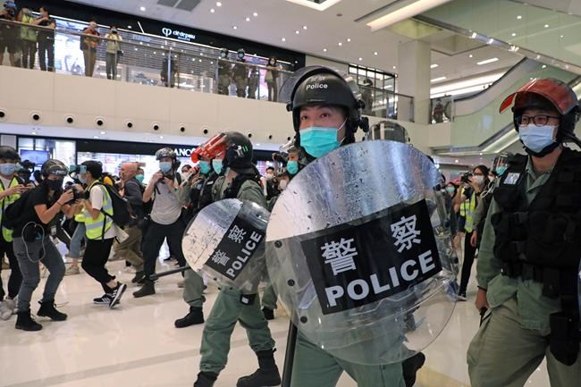 Riot police enter the shopping mall to disperse the protesters during the Labor Day in Hong Kong, Friday, May 1, 2020 amid the coronavirus COVID-19 pandemic. Hong Kong police deployed pepper spray during a protest in a Hong Kong shopping mall on Friday, as they dispersed over a hundred protesters who gathered to sing and chant pro-democracy slogans. (AP Photo/Kin Cheung)