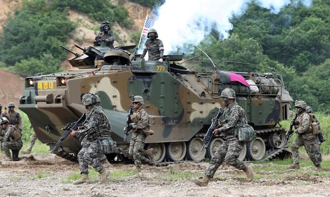 FILE - In this July 6, 2016, file photo, South Korea and U.S. marines participate in a joint military exercise between South Korea and the United States in Pohang, South Korea. The number of new virus cases in South Korea jumped again Wednesday and the first U.S. military soldier tested positive, with his infection and many others connected to a southeastern city where the outbreak has clustered. The U.S. military is urging its personnel to avoid handshakes and non-mission essential large gatherings. (Kim Joon-bum/Yonhap via AP, File)