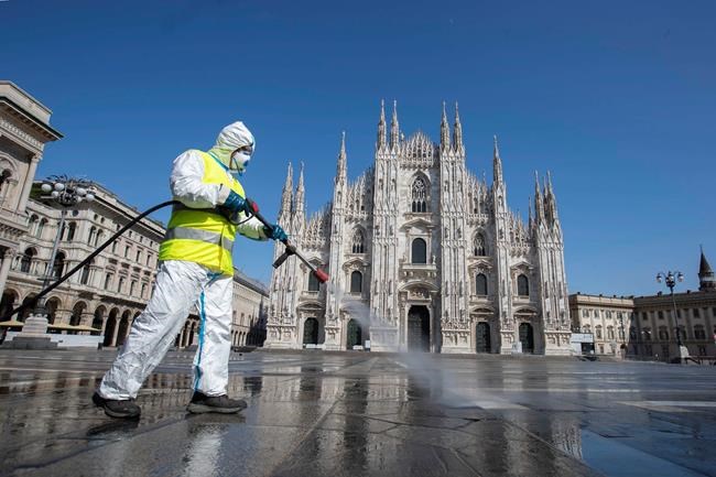 A worker sprays disinfectant to sanitize Duomo square, in downtown Milan, Italy, Tuesday, March 31, 2020. The new coronavirus causes mild or moderate symptoms for most people, but for some, especially older adults and people with existing health problems, it can cause more severe illness or death. (AP Photo/Luca Bruno)