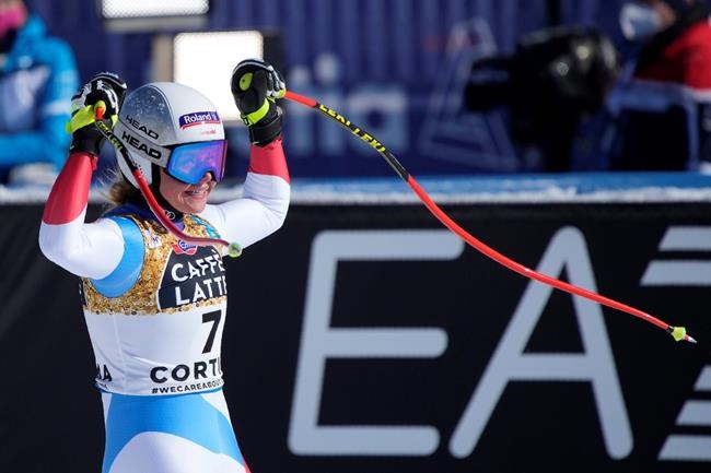 Switzerland's Corinne Suter celebrates as she gets to the finish area after completing the women's downhill, at the alpine ski World Championships in Cortina d'Ampezzo, Italy, Saturday, Feb. 13, 2021. (AP Photo/Giovanni Auletta)