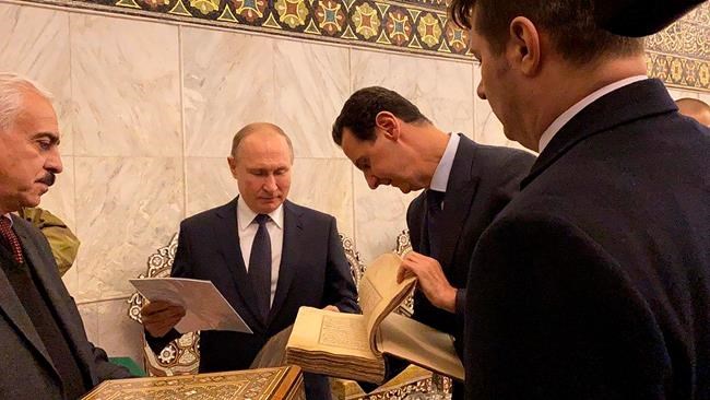 This image released by the Syrian Presidency shows Russian President Vladimir Putin, center, and Syrian President Bashar Assad, second right, during a visit to the Umayyad Mosque in Damascus, Syria, Tuesday, Jan. 7, 2020. Putin's visit is the second to the war-torn country where his troops have been fighting alongside Syrian government forces since 2015. (Syrian Presidency via AP)