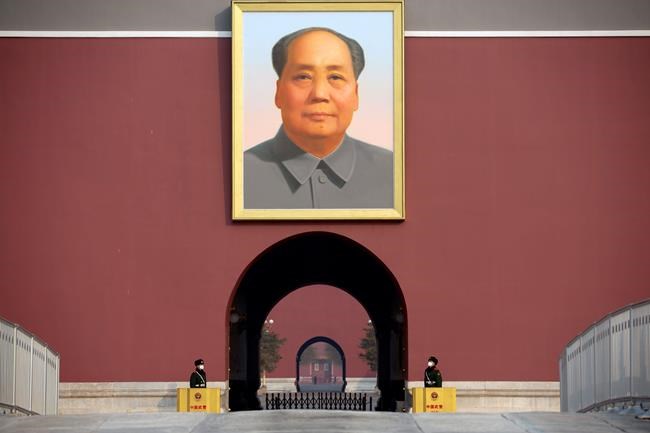 Chinese paramilitary police wear face masks as they stand guard beneath the large portrait of Chinese leader Mao Zedong at Tiananmen Gate adjacent to Tiananmen Square in Beijing, Monday, Jan. 27, 2020. China on Monday expanded sweeping efforts to contain a viral disease by postponing the end of this week's Lunar New Year holiday to keep the public at home and avoid spreading infection. (AP Photo/Mark Schiefelbein)