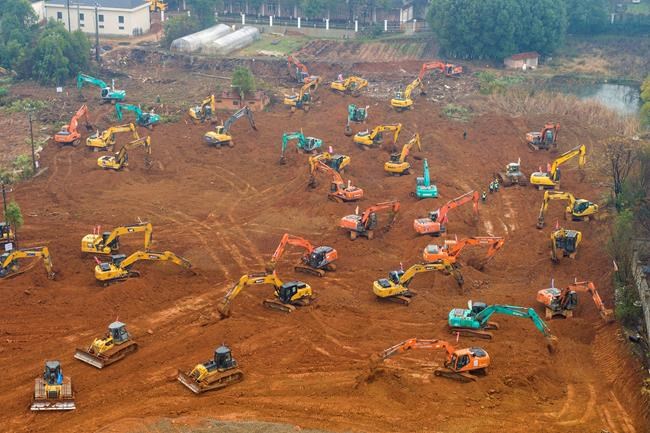 Heavy equipment works at a construction site for a field hospital in Wuhan in central China's Hubei Province, Friday, Jan. 24, 2020. China is swiftly building a 1,000-bed hospital dedicated to patients infected with a new virus that has killed 26 people, sickened hundreds and prompted unprecedented lockdowns of cities during the country's most important holiday. (Chinatopix via AP)