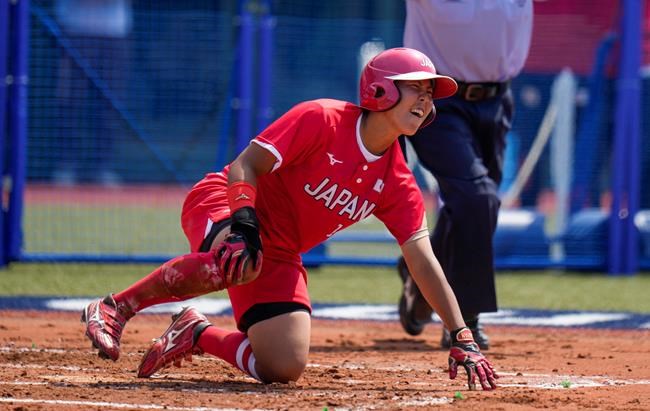 Japan's Minori Naito reacts after sliding into home base during the softball game between Japan and Australia at the 2020 Summer Olympics, Wednesday, July 21, 2021, in Fukushima, Japan. (AP Photo/Jae C. Hong)
